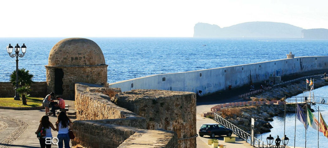 Alghero e i suoi bastioni, sullo sfondo Capo Caccia e la riviera del Corallo, Magazine Emozione Sardegna