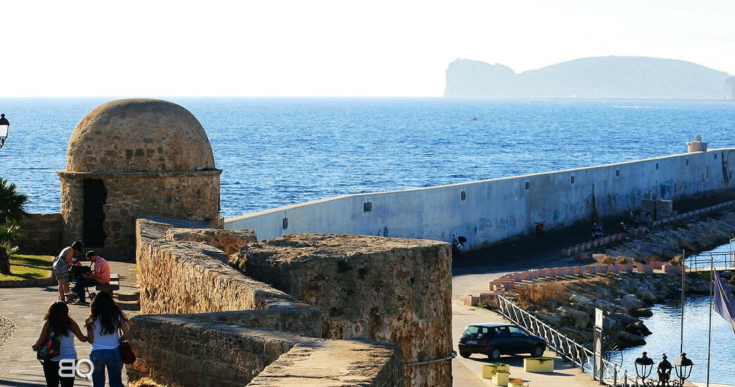 Alghero e i suoi bastioni, sullo sfondo Capo Caccia e la riviera del Corallo, Magazine Emozione Sardegna